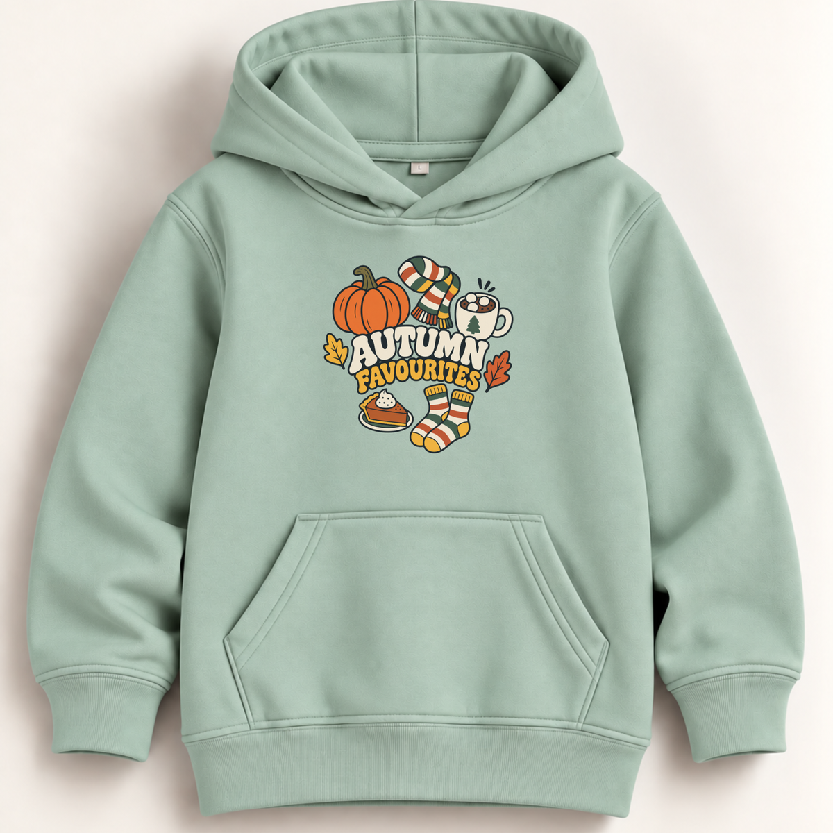 A mint green kids' pullover hoodie with a front kangaroo pocket and a colorful autumn-themed graphic on the chest that reads 'AUTUMN FAVOURITES' with a pumpkin, striped socks, a mug, and a pie.