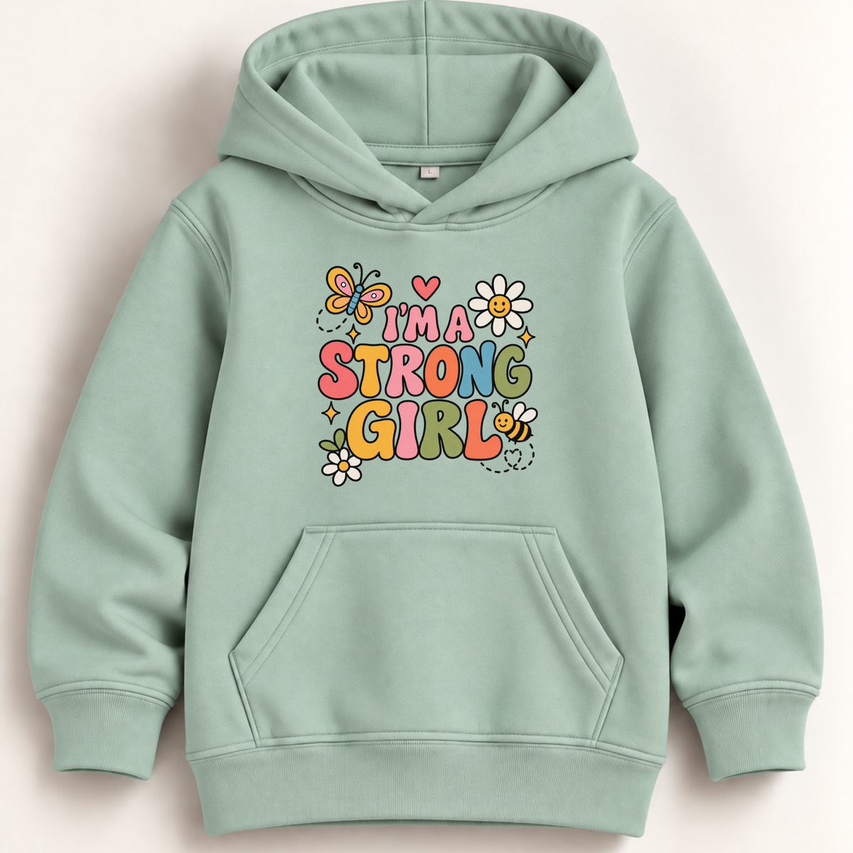 A mint green pullover hoodie with a colorful graphic on the chest that reads 'I'M A STRONG GIRL' surrounded by flowers, bees, and butterflies, displayed on a light beige background.