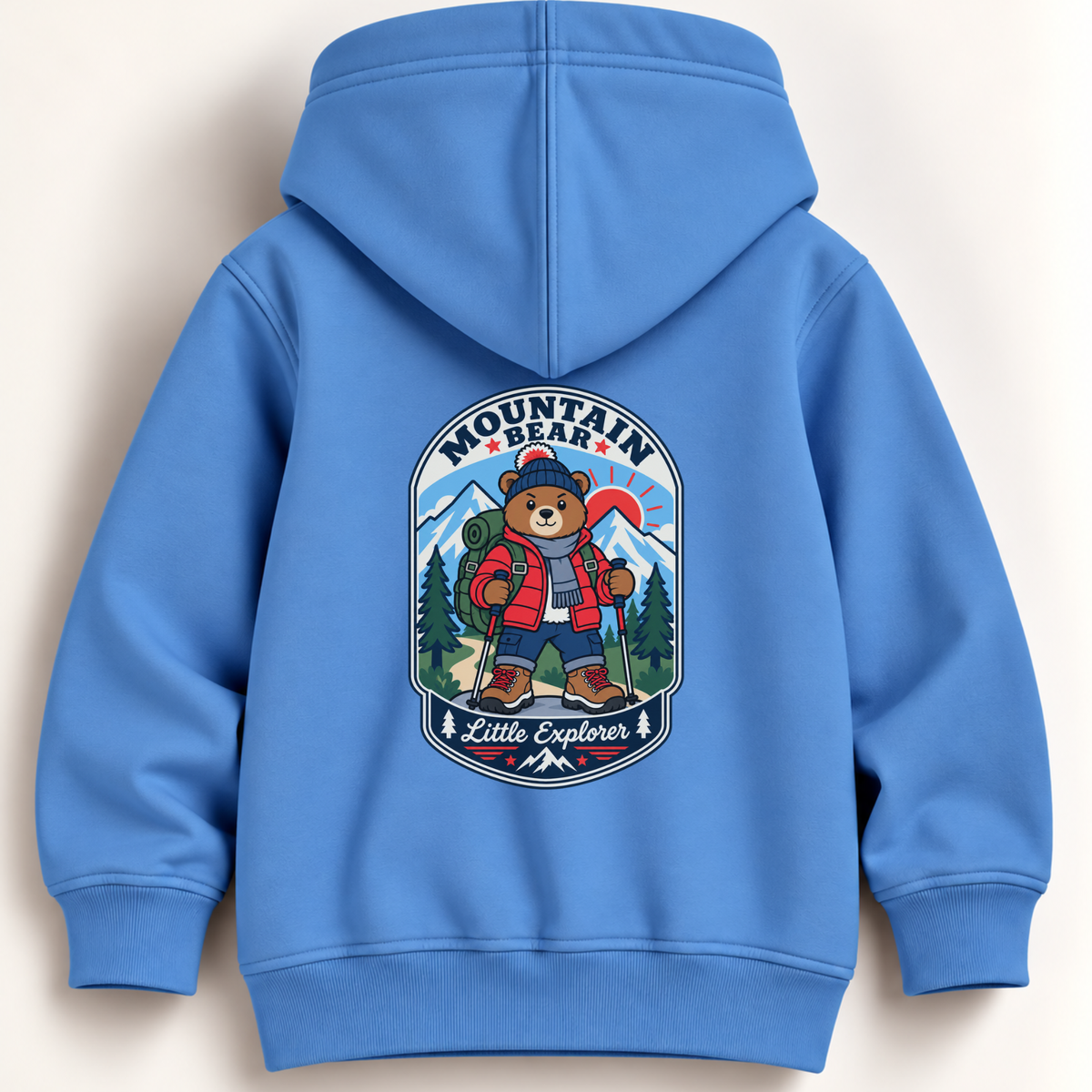 A light blue hooded sweatshirt shown from the back, featuring a large cartoon bear graphic with the words 'Mountain Bear Little Explorer' and outdoor elements like trees, mountains, and a backpack.