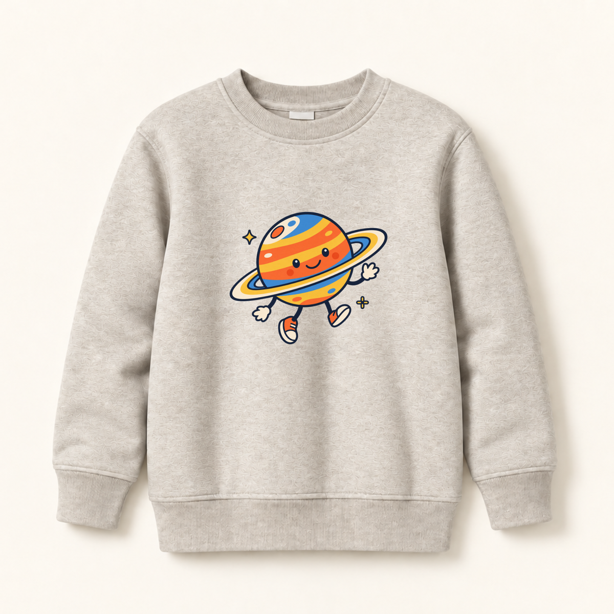 A light heather gray crewneck sweatshirt featuring a colorful cartoon graphic of a smiling planet with a ring and small legs, displayed on a clean off-white background.