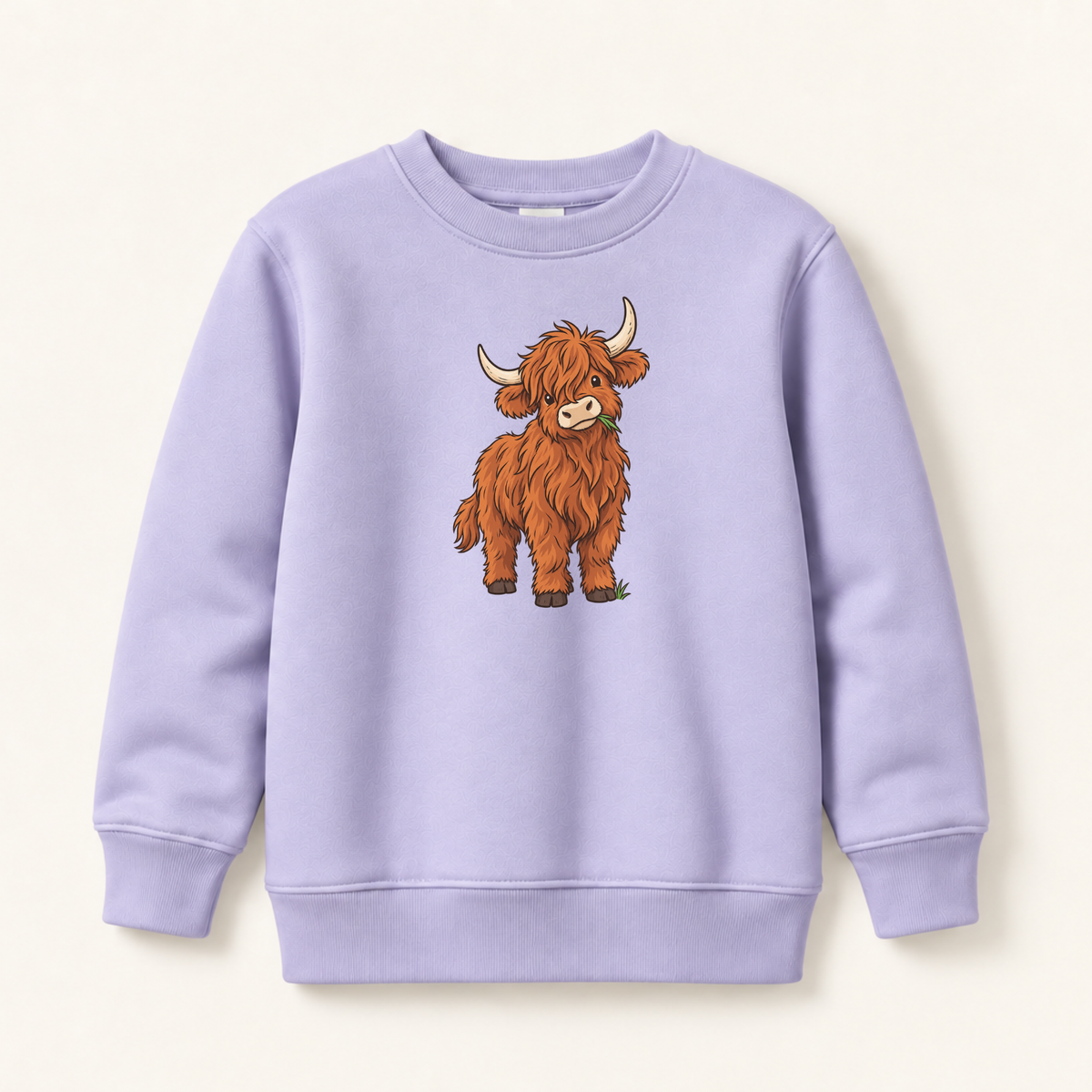 A light lavender crewneck sweatshirt featuring a cartoon illustration of a fluffy brown Highland cow on the front, displayed against a warm off-white background.