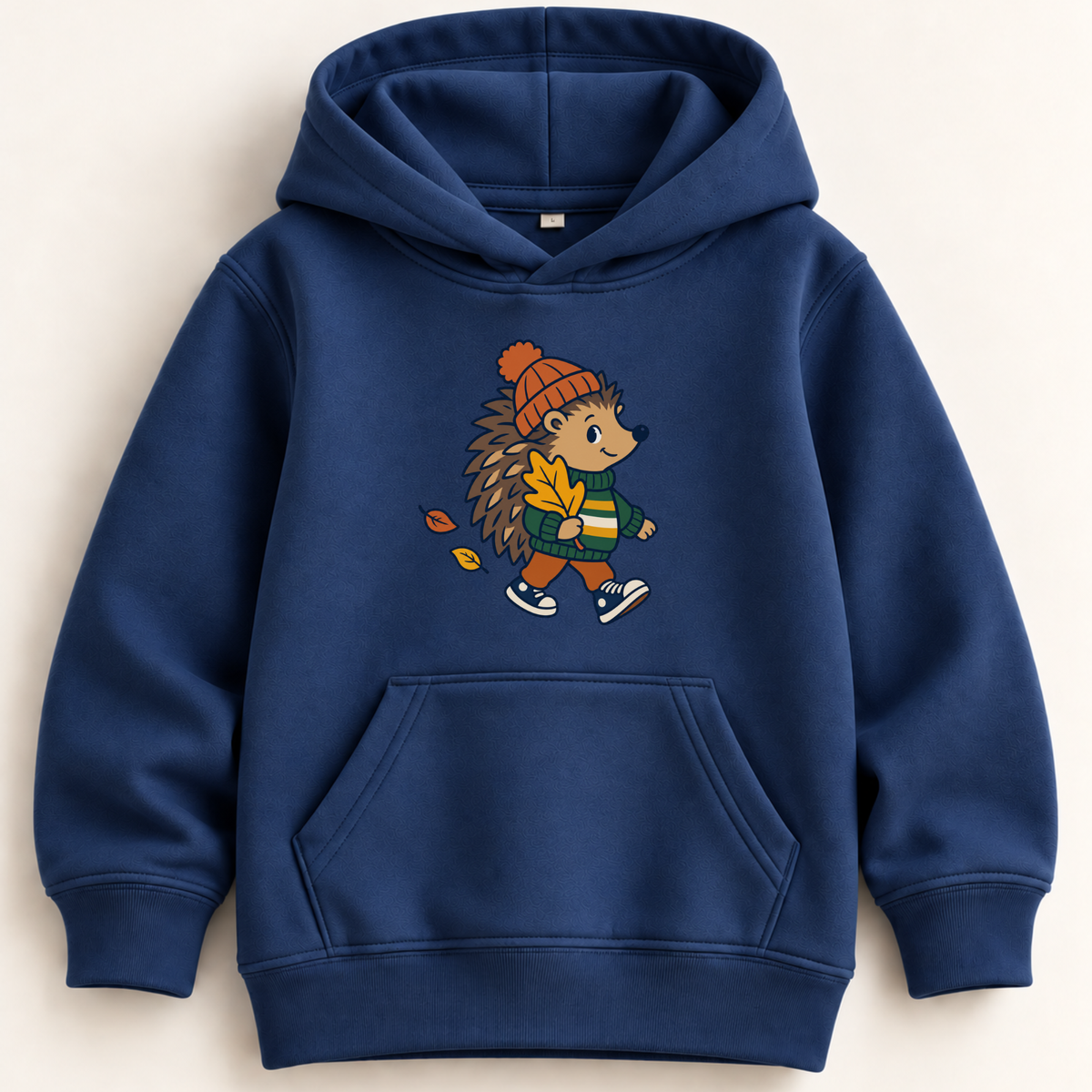 A navy blue kids' pullover hoodie with a front kangaroo pocket and a central graphic of a walking hedgehog wearing an orange beanie and holding autumn leaves.