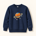 A navy blue crewneck sweatshirt featuring a cute cartoon graphic of a smiling planet with a ring on the front, displayed against a light cream background.