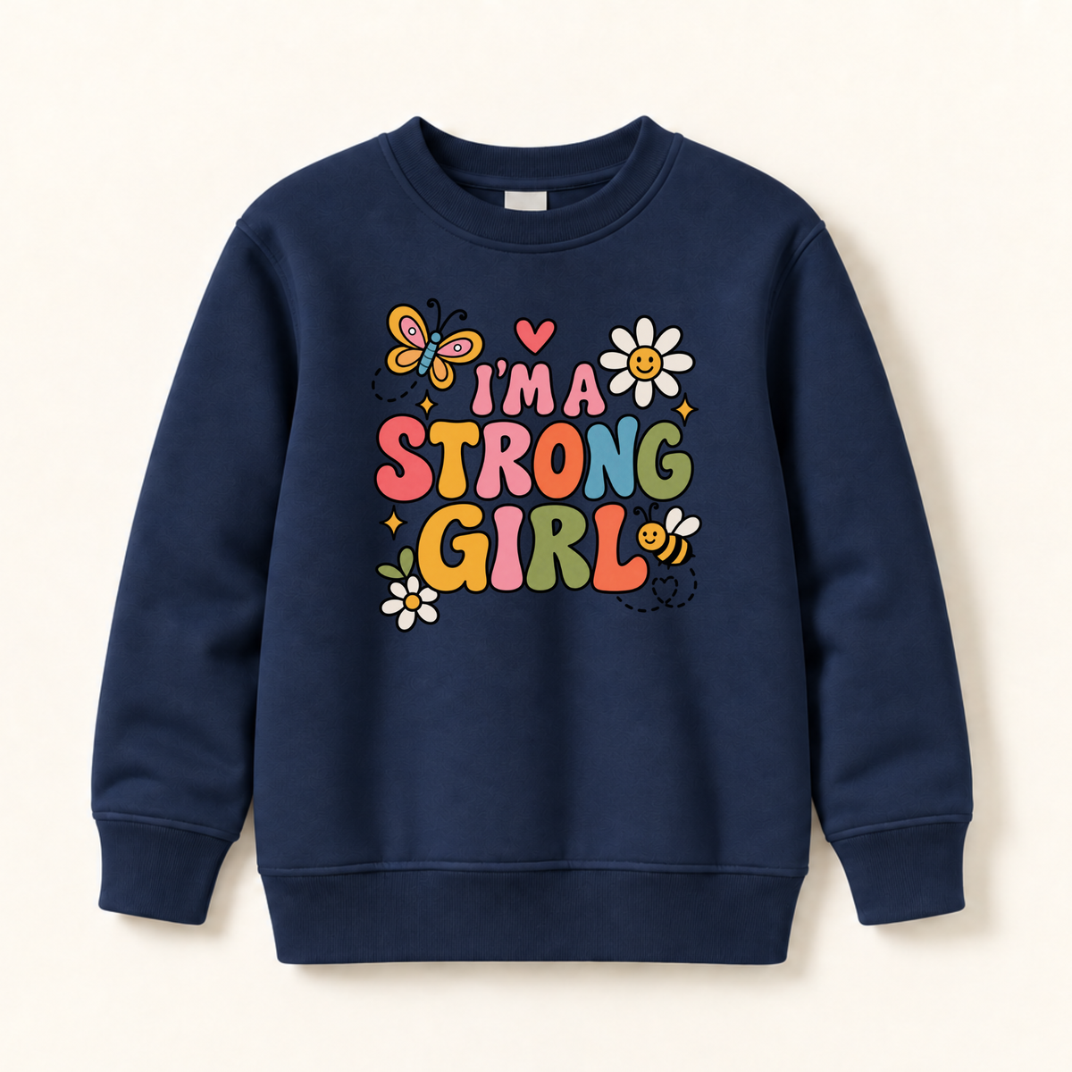 A navy blue crewneck sweatshirt featuring a colorful graphic print on the front that reads 'I'M A STRONG GIRL' with cartoon butterflies, flowers, and a bee, displayed against a light cream background.