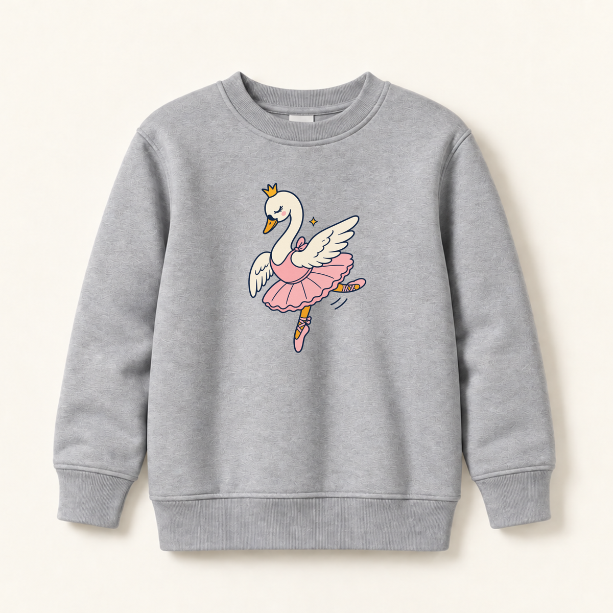 A light gray heather crewneck sweatshirt featuring a cartoon graphic of a white swan ballerina with a pink tutu and gold crown, displayed on a warm off-white background.