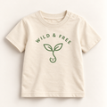 A cream-colored short-sleeve baby t-shirt with 'WILD & FREE' and a green sprout graphic printed on the front, displayed flat against a light cream background.