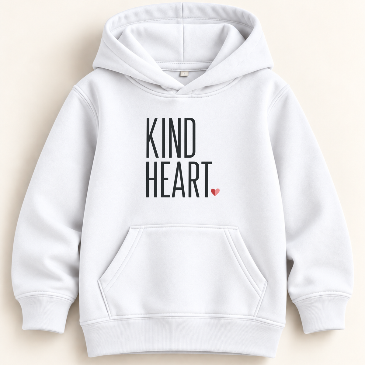 A white pullover hoodie with 'KIND HEART.' printed in black block letters on the chest and a small red heart accent, shown on a light beige background.