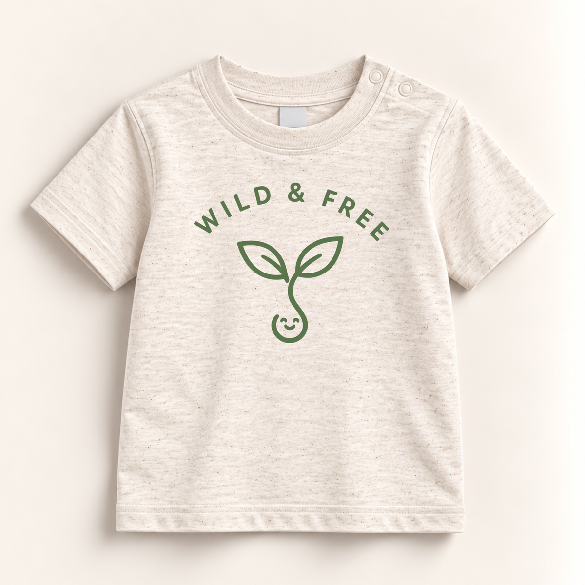 A baby t-shirt in a light heathered cream color with a green graphic of a sprout and the words 'WILD & FREE' printed on the front, displayed flat against a light beige background.